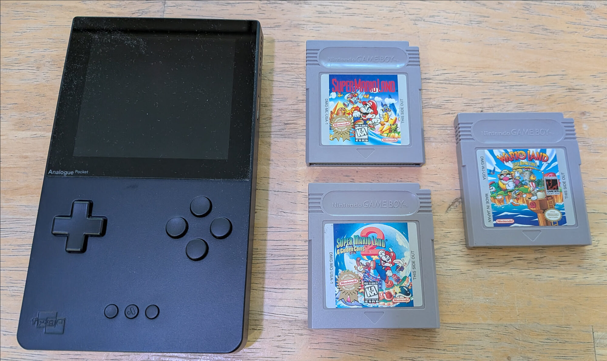 My Analogue Pocket next to Game Boy cartridges: Super Mario Land, Super Mario Land 2 and Wario Land
